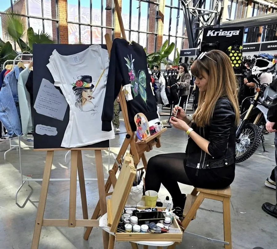 Simona Bușoiu hand-painting a t-shirt at an event